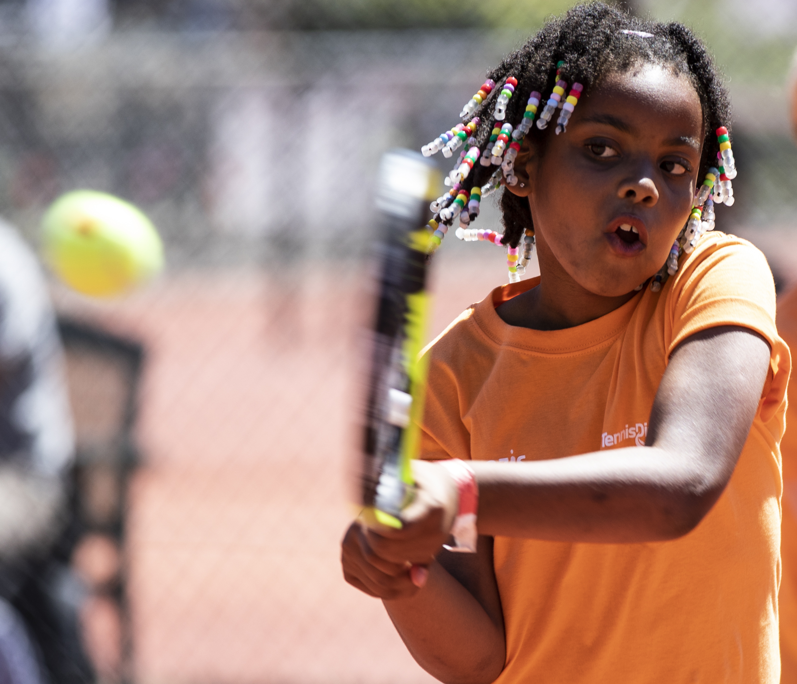 tenniskids oranje diversiteit meisje backhand dreads