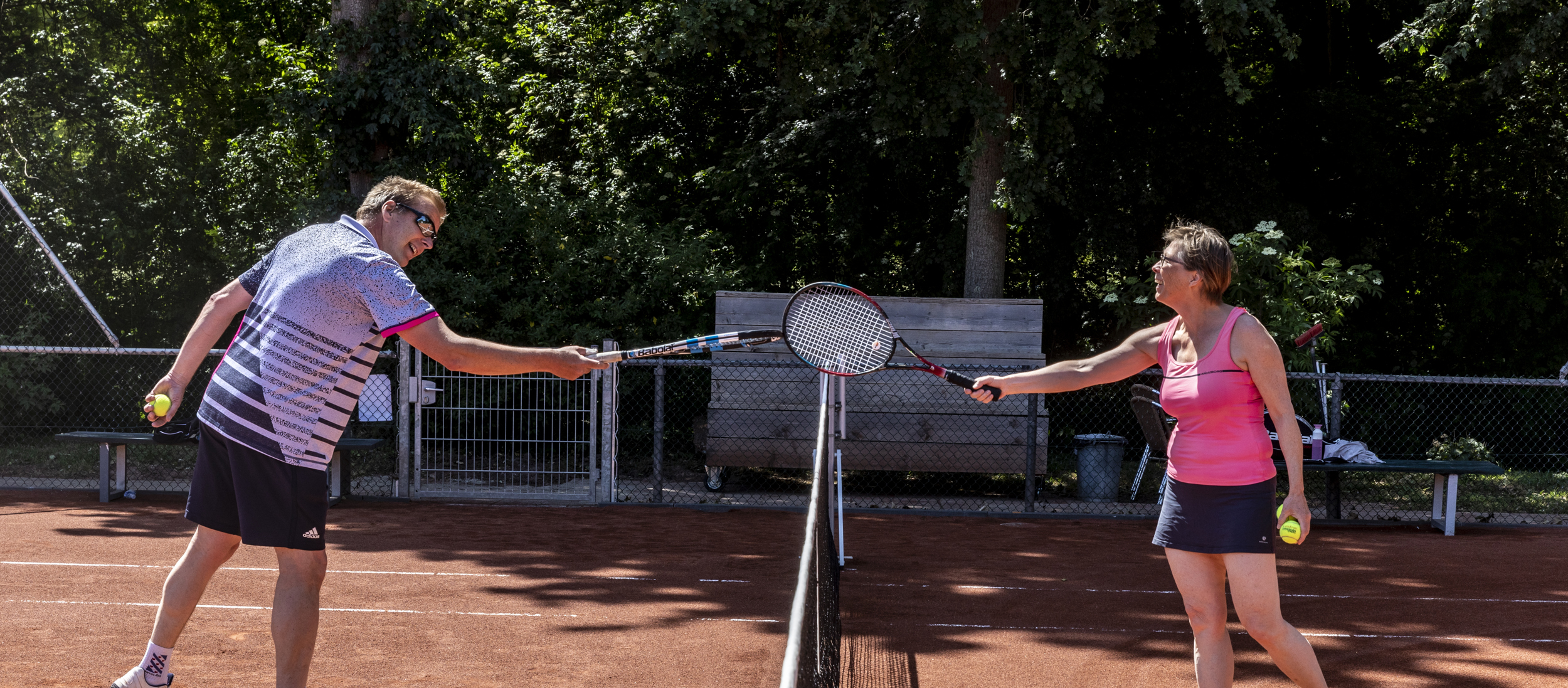 Man en vrouw corona afstand racket highfive net